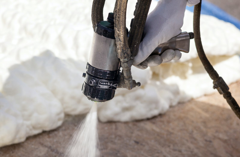 contractor spraying foam with tool